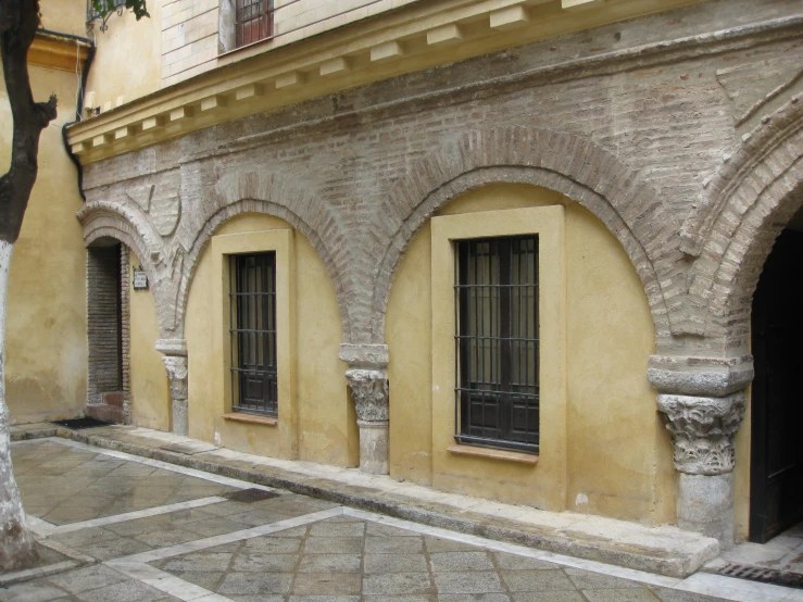 a stone wall with arched windows in front of it