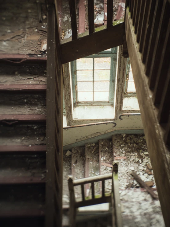 view down into a rundown home from below a set of stairs