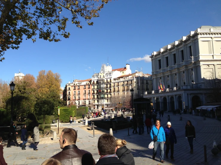 people walking in a city square during a sunny day