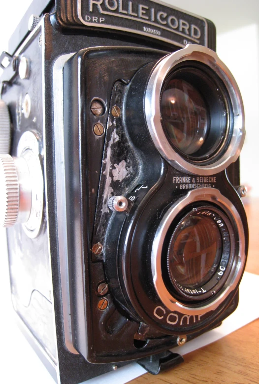 a small old fashioned camera sitting on top of a table