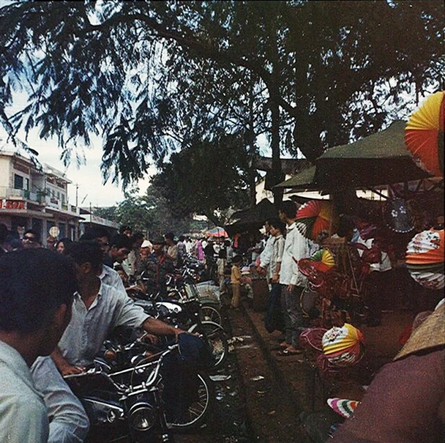 a street with many people looking at their bikes