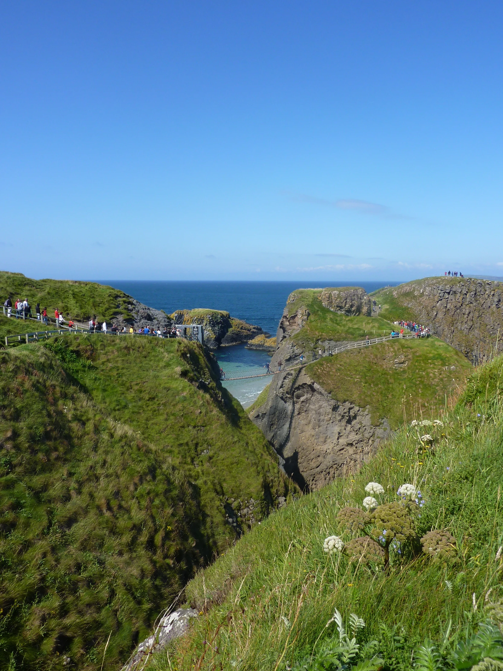 a person riding a horse near a body of water and a cliff with many houses