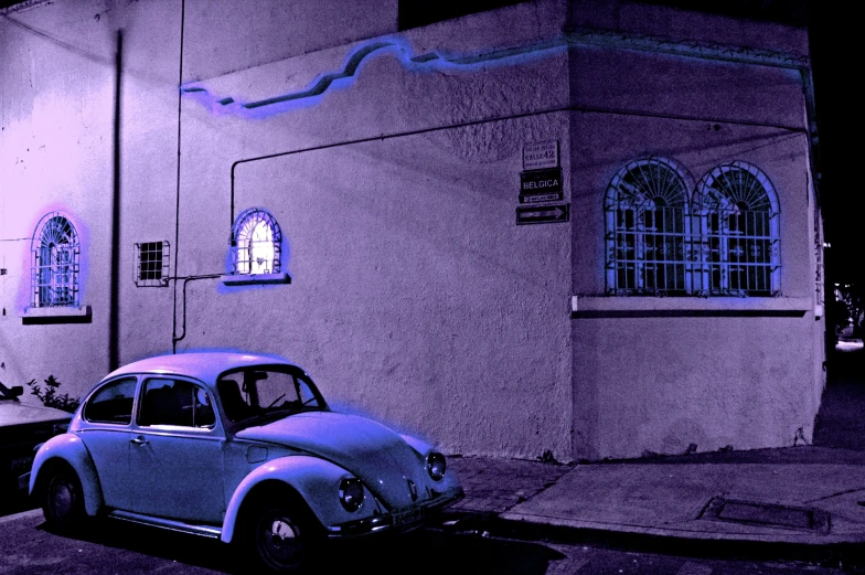 a purple filter has been used to contrast this car on the sidewalk