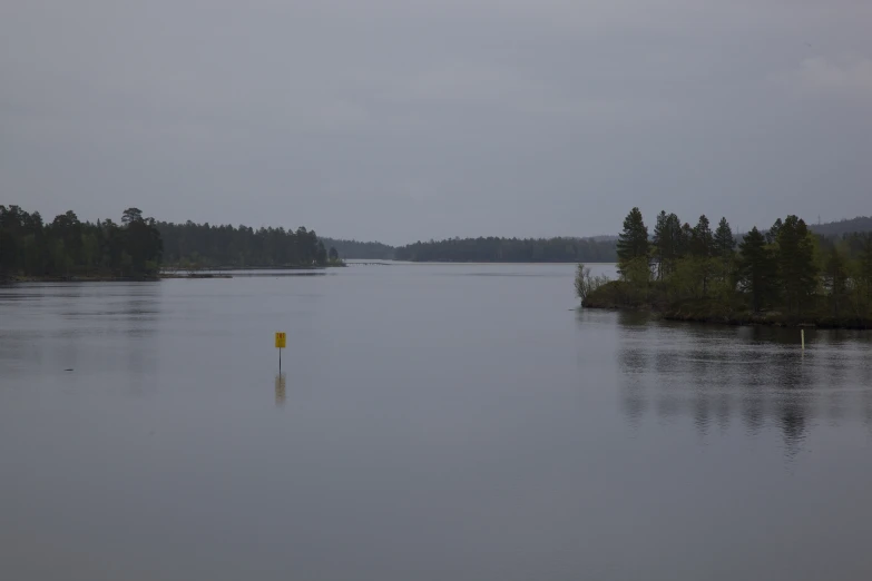 a large body of water near trees and hills