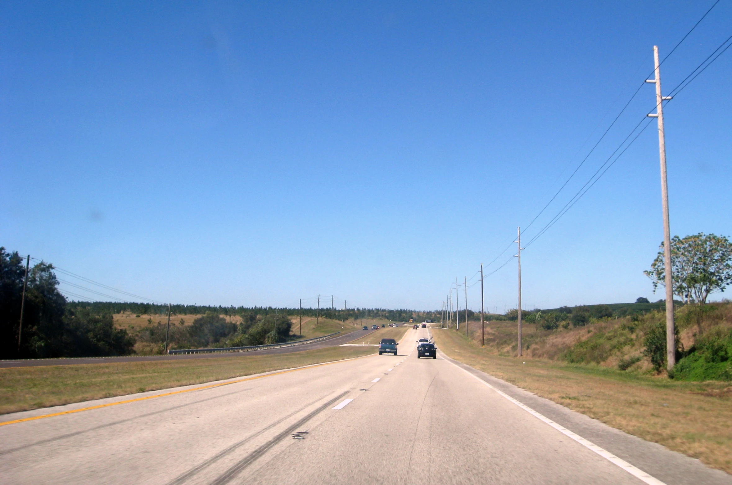 two cars driving down a country road