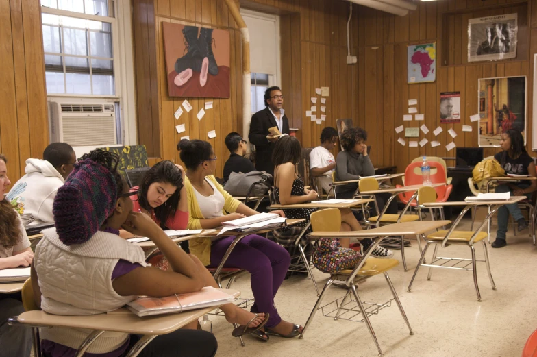 there is a classroom that has people seated at desks