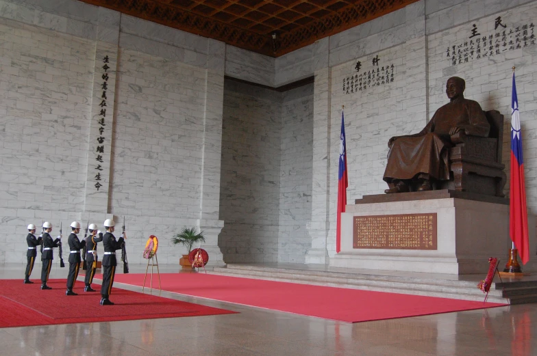 there is a red carpet that has some soldiers standing in front of a statue