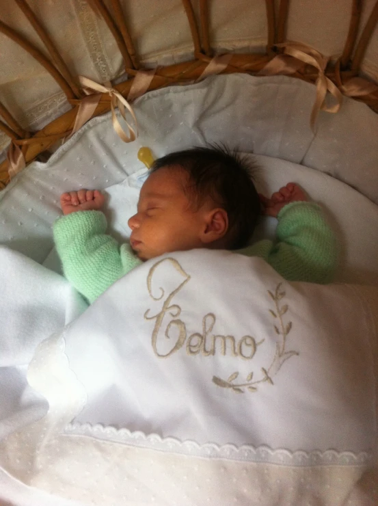 baby laying in a crib with a name on it