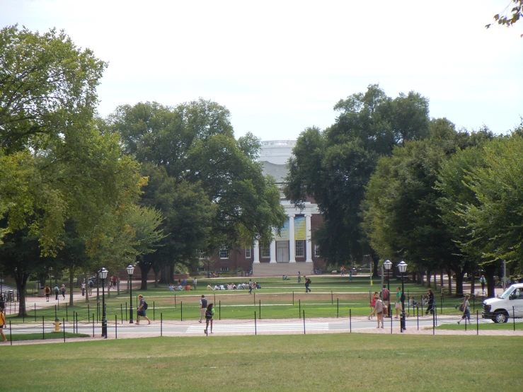 some people in the park and there is a building