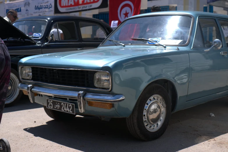 blue old car parked next to another one with no wheel tires