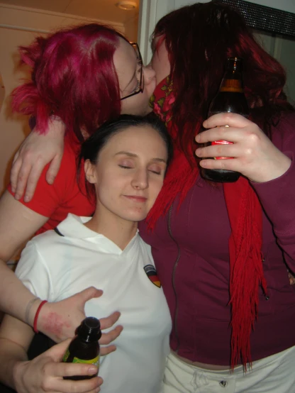 two girls kiss and hug each other with alcohol