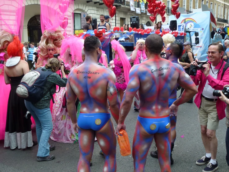 many colorful figures, with body paint and head pieces on each side