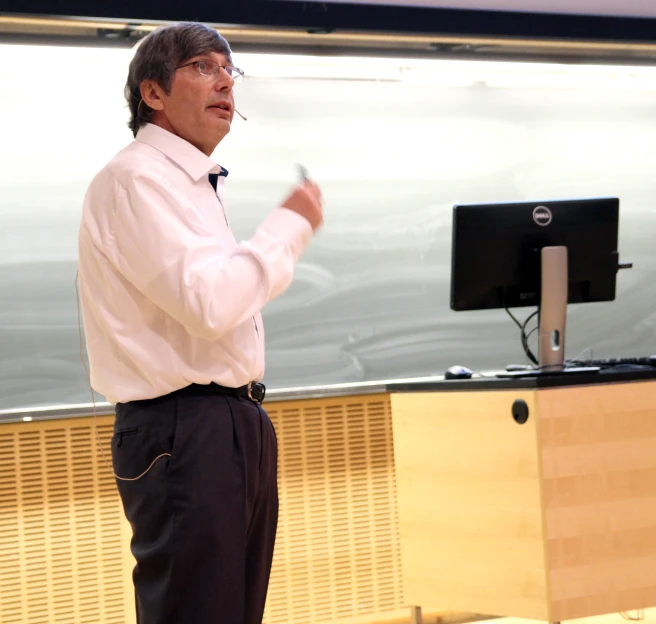 a man is talking with an audience in the background