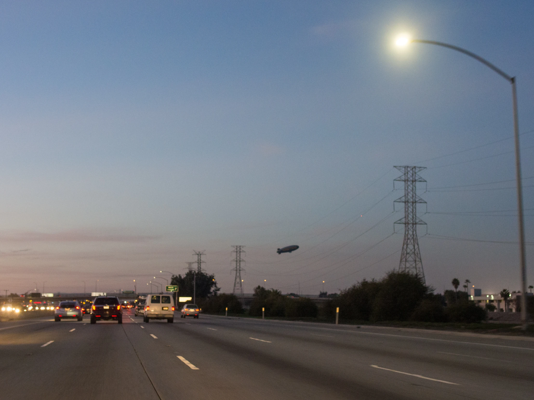 cars driving down the highway with the headlights on