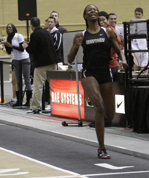 a woman wearing black running down a race track