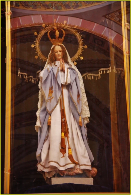 the statue of virgin mary stands in a glass case