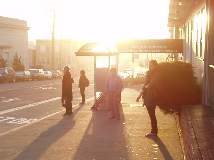 the woman is carrying her luggage down the sidewalk