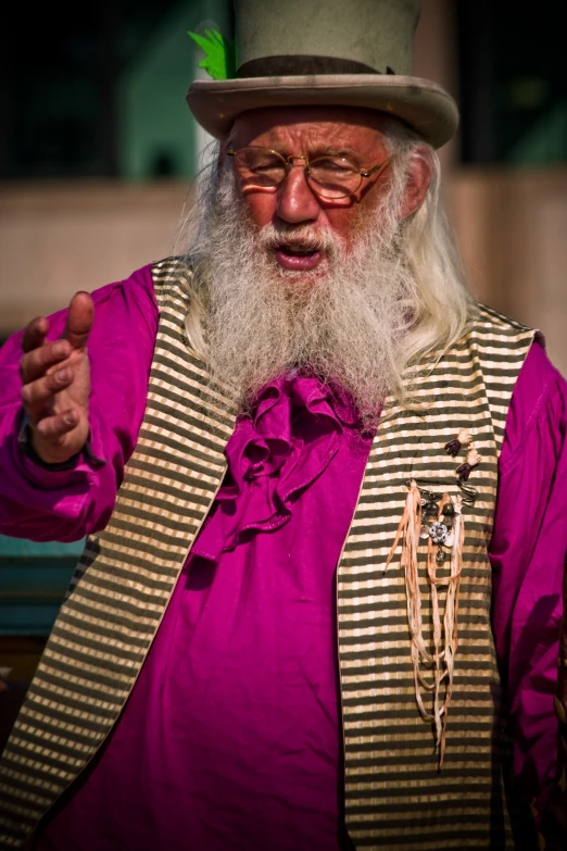 an older man with a white beard and hat has a green feather