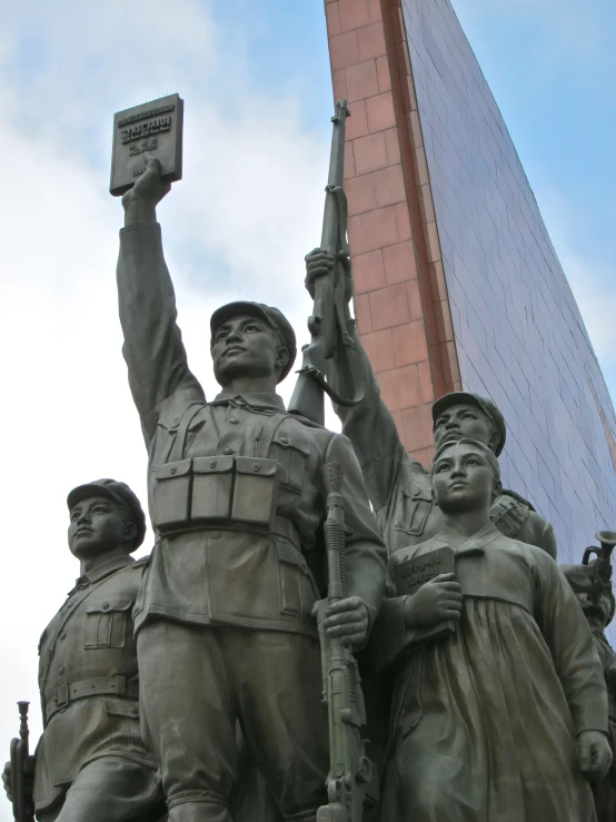 some statues stand with one holding an award