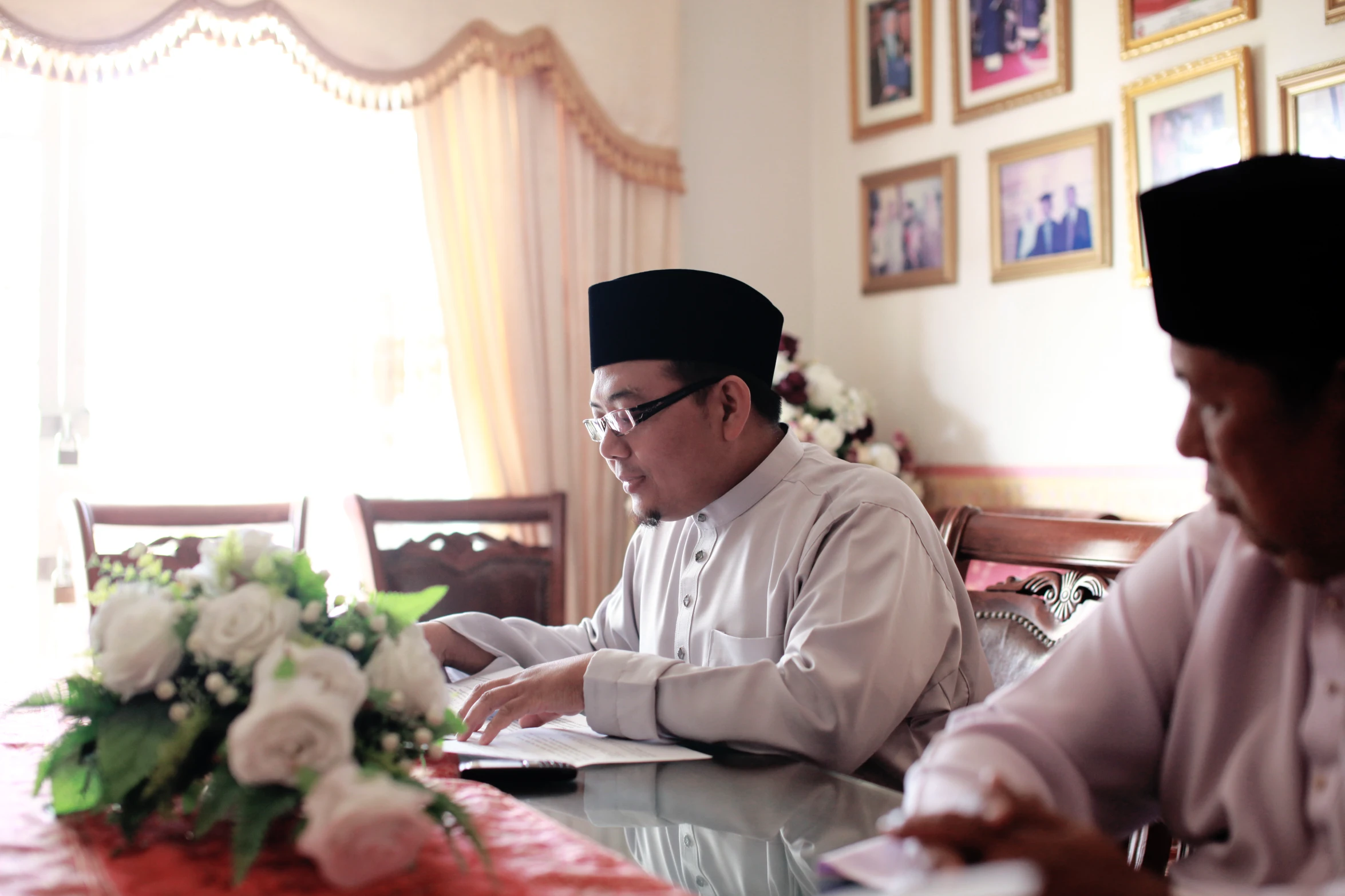 two people sitting at a table looking at some papers