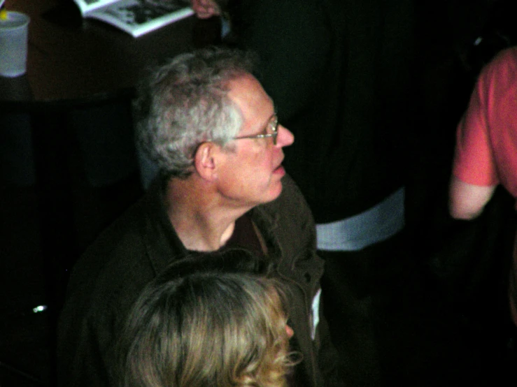 a man sitting down in front of two other people