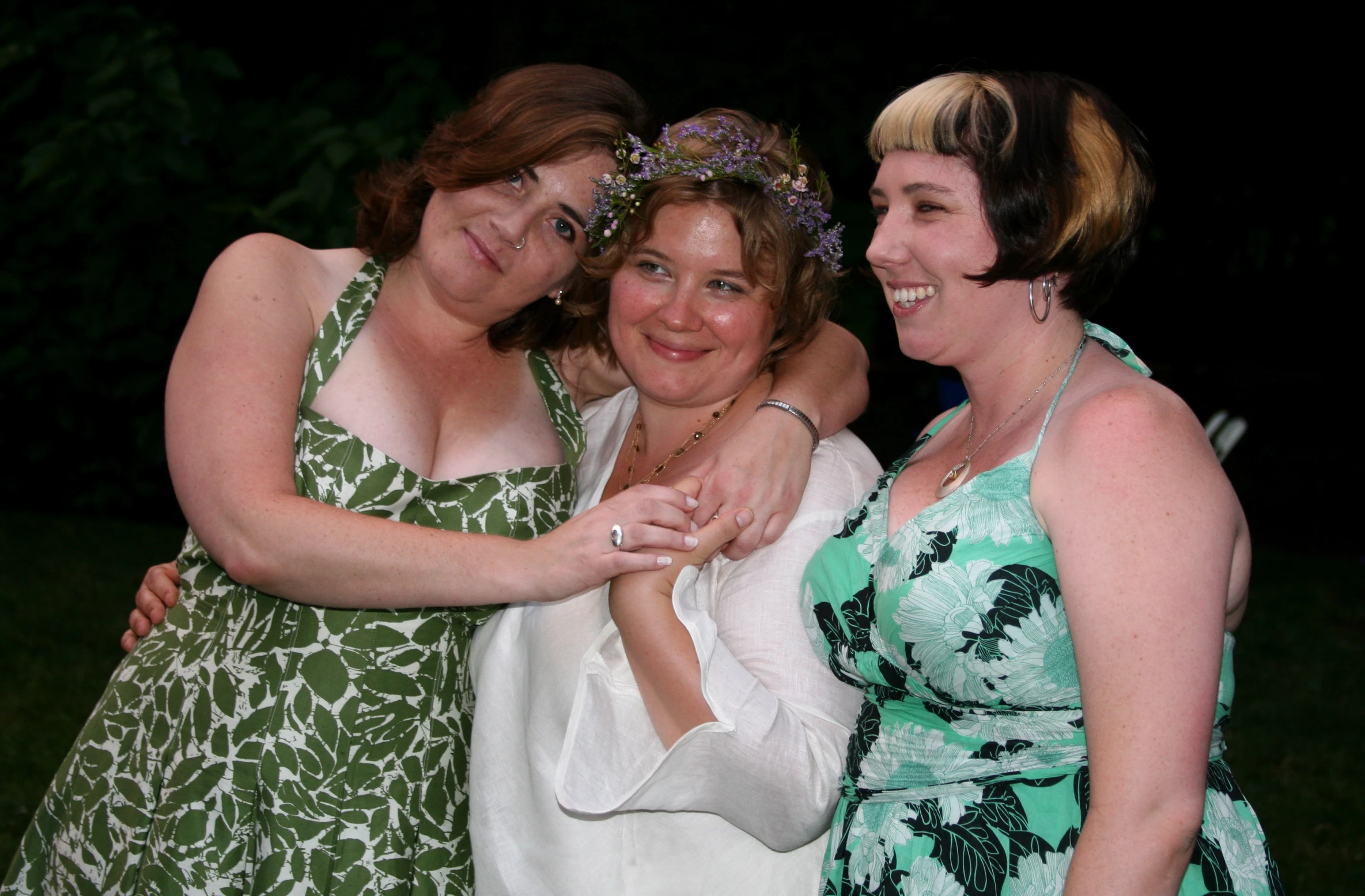 three women in dresses with white towels and a necklace