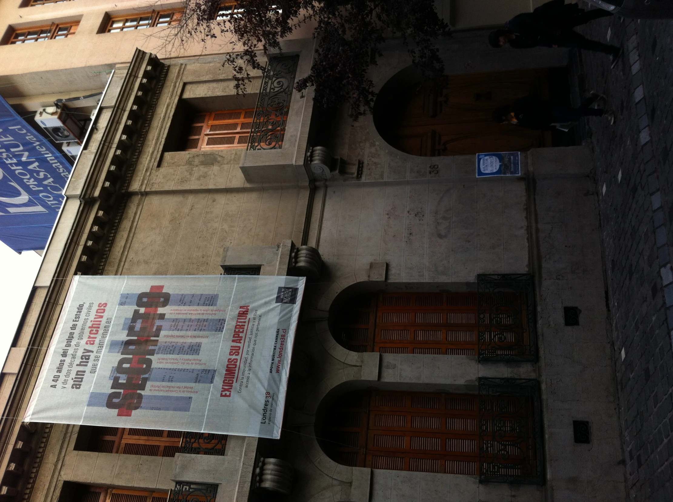 people are walking past an old brick building