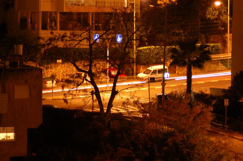 some vehicles moving along the roadway at night