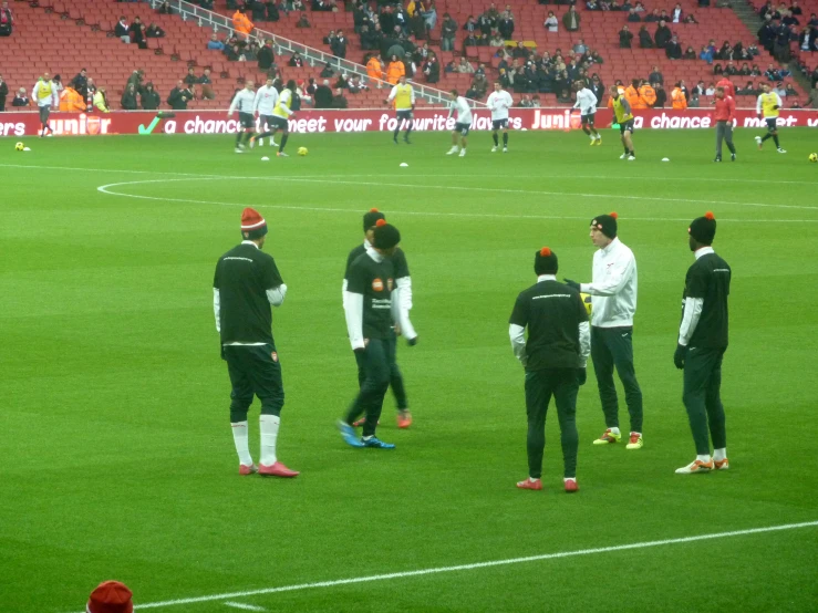 several men on a soccer field with a red hat