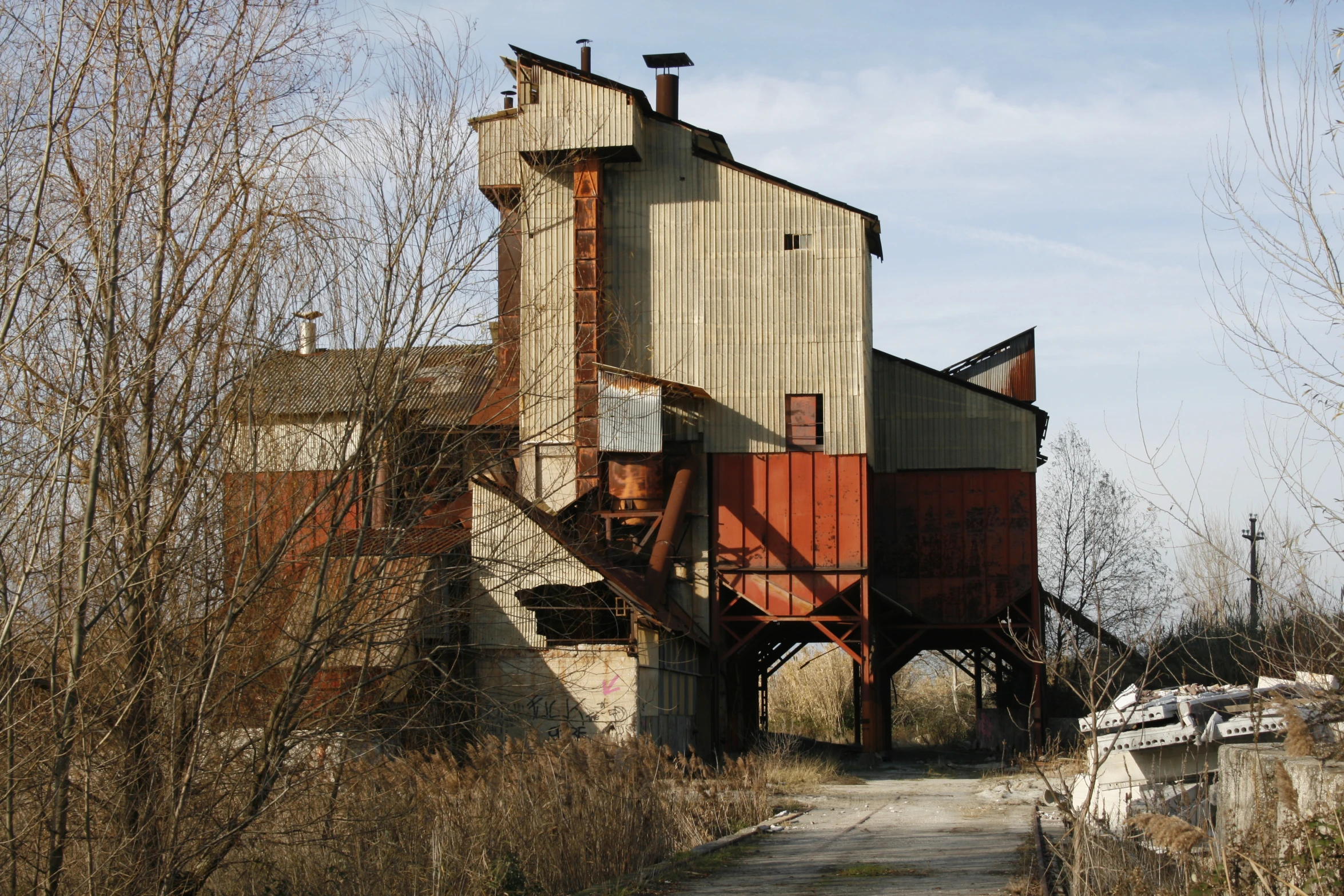 a small grain elevator near a long dirt trail