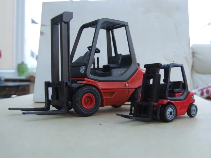 small toy car and fork lift sitting next to each other