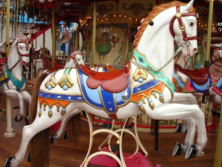 a carousel with three horses and merry go round