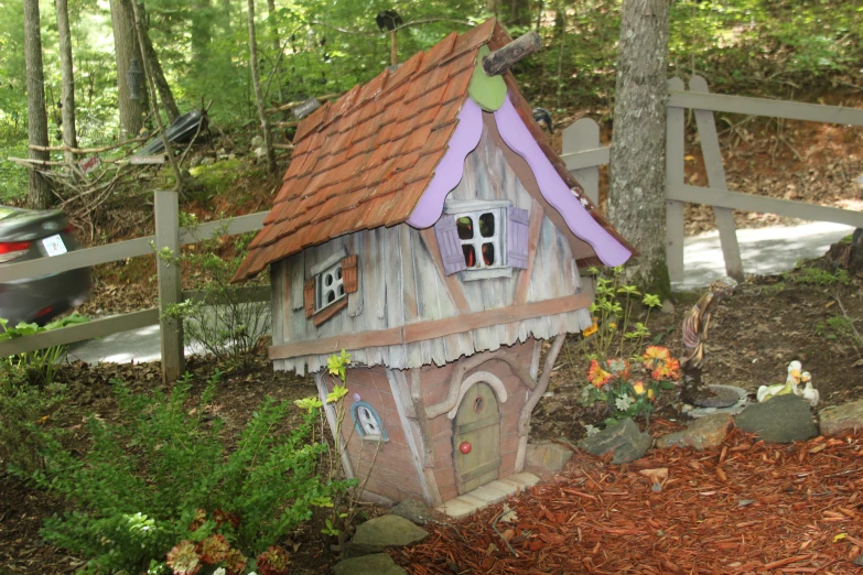 a little pink and brown building with a red roof