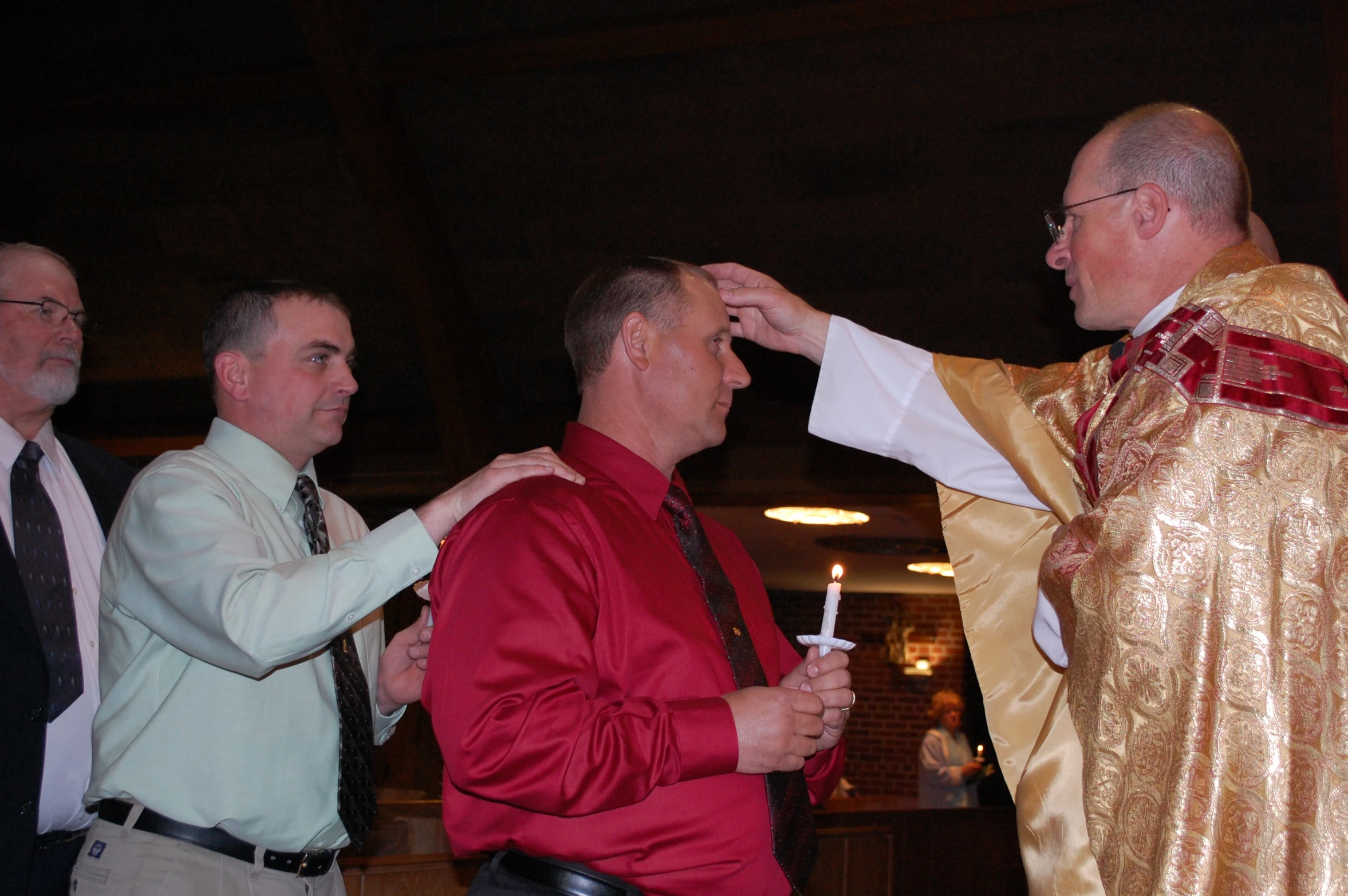 a priest is bowing his forehead to a man