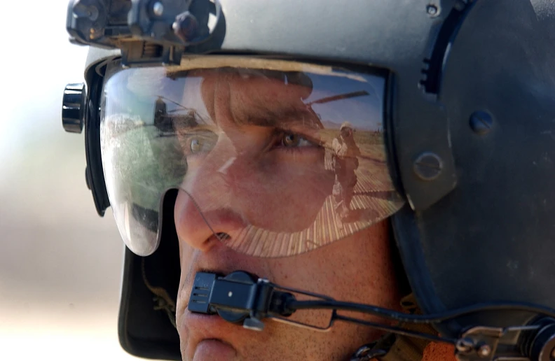 a man wearing an all terrain helmet has his face reflected