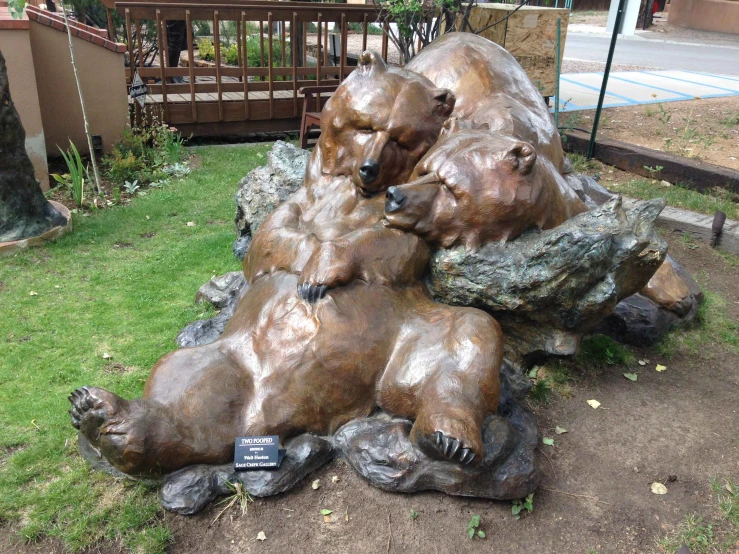 a statue of two bears lying in grass