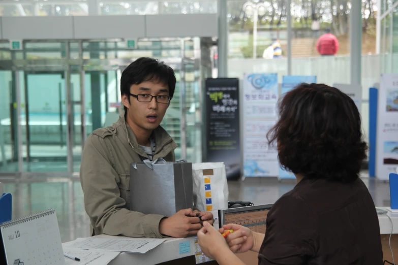 woman handing a man a check in in an airport