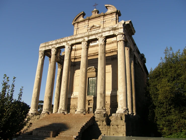 a very tall building with many columns and a clock on the top