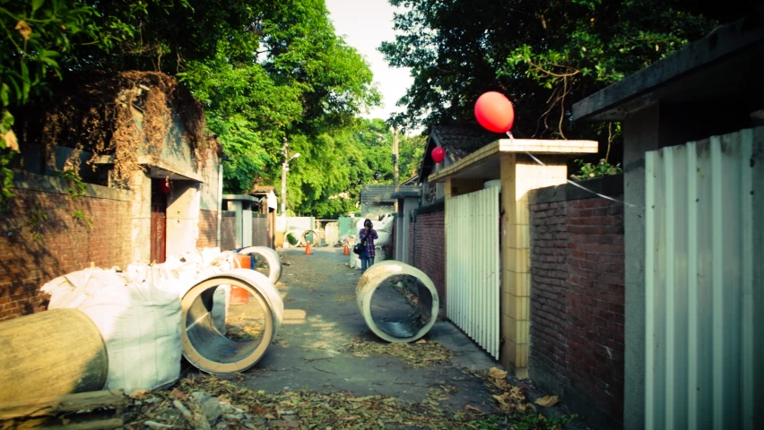 a street with trees, trash bags, and fencing