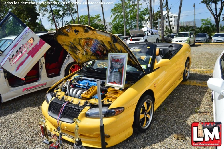 an open top yellow sports car is on display