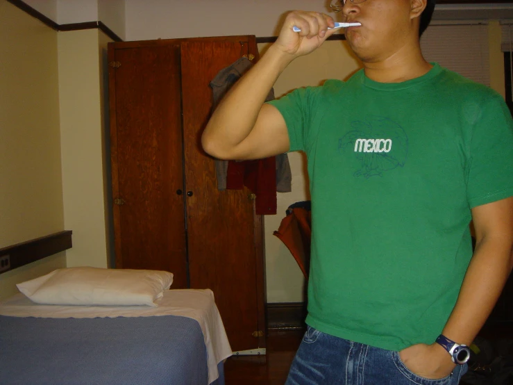 an asian male with a toothbrush in his mouth