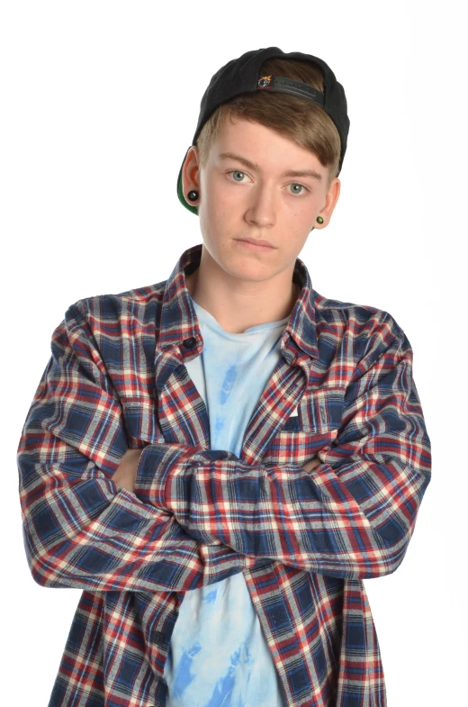 a boy in a plaid shirt with his arms crossed