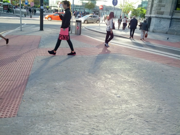 a woman walking down the middle of a street while talking on a phone