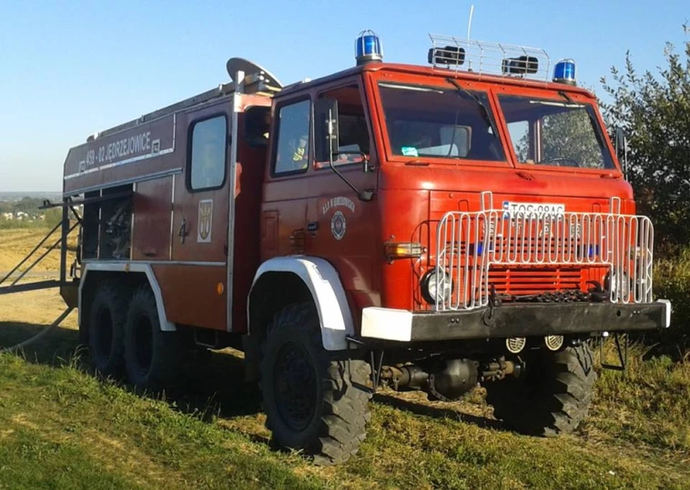 a red fire engine parked next to a green field