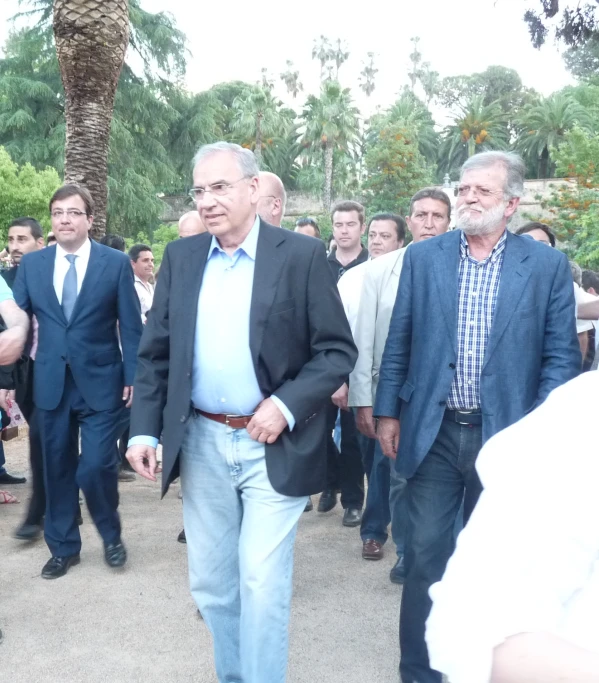 several men in suits walking around near other people