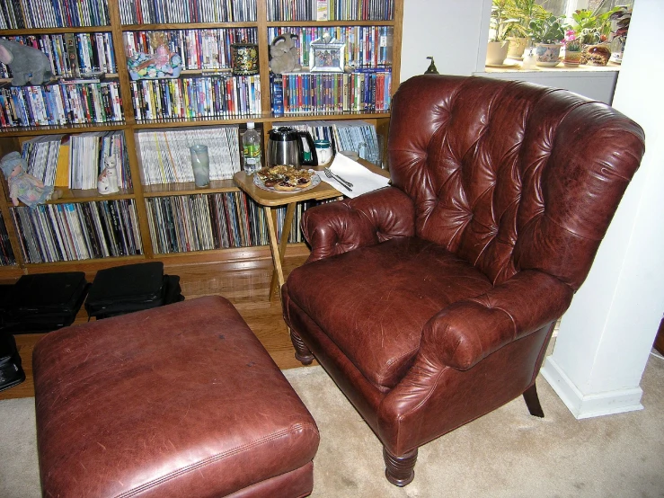 a leather recliner chair and ottoman in a den with lots of books