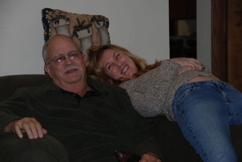 a woman and a man laying down on a sofa