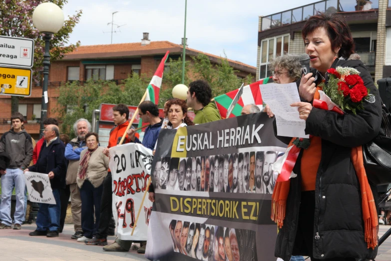 the people stand on a street holding protest signs