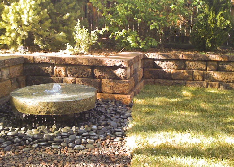 a fountain in the middle of a garden area