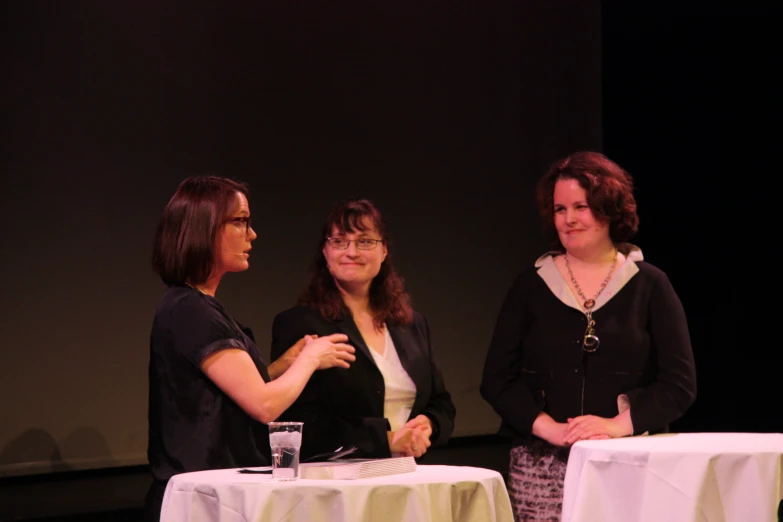 three women are having a conversation at a table